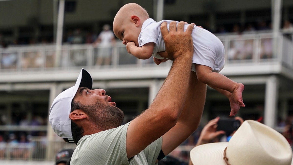 Scottie Scheffler sostiene a su hijo