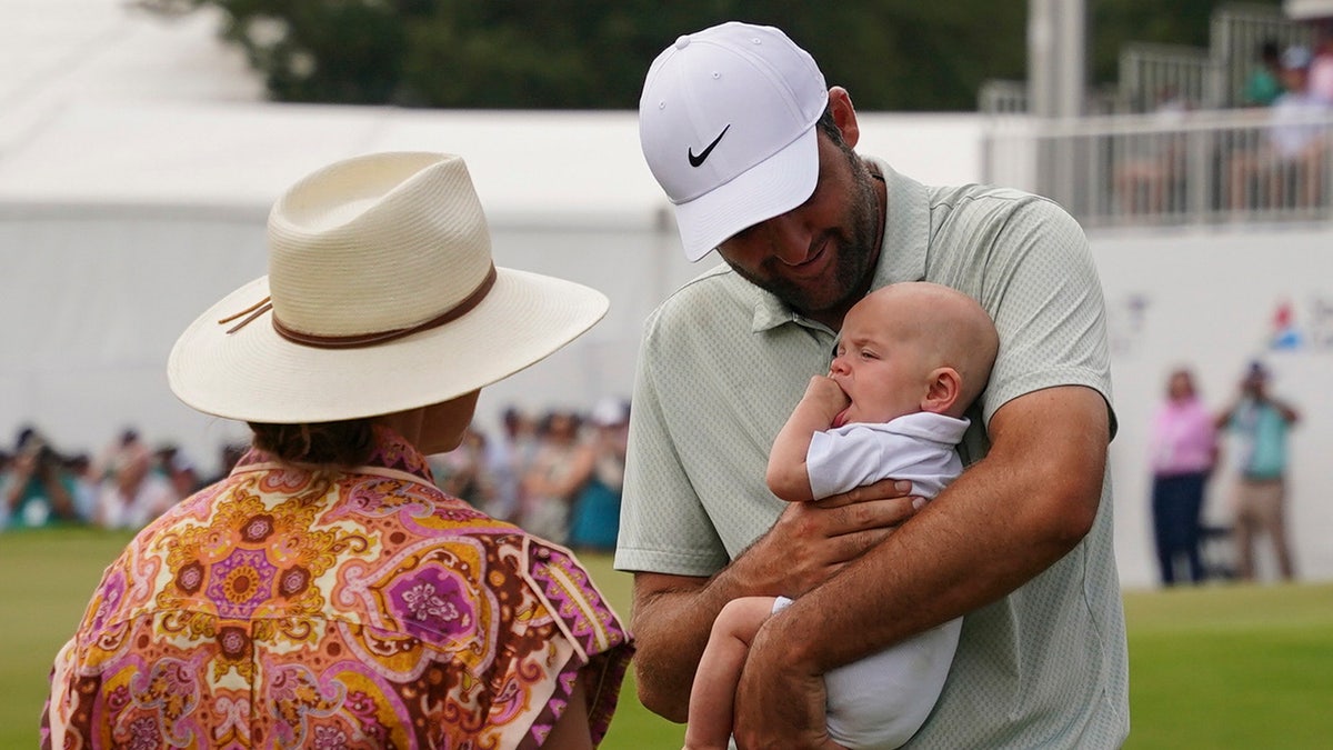 Scottie Scheffler sostiene a su hijo Bennett