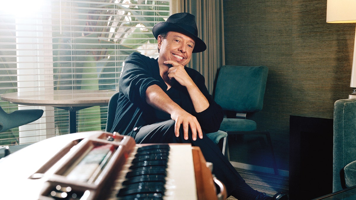 Sergio Mendes sits by a keyboard