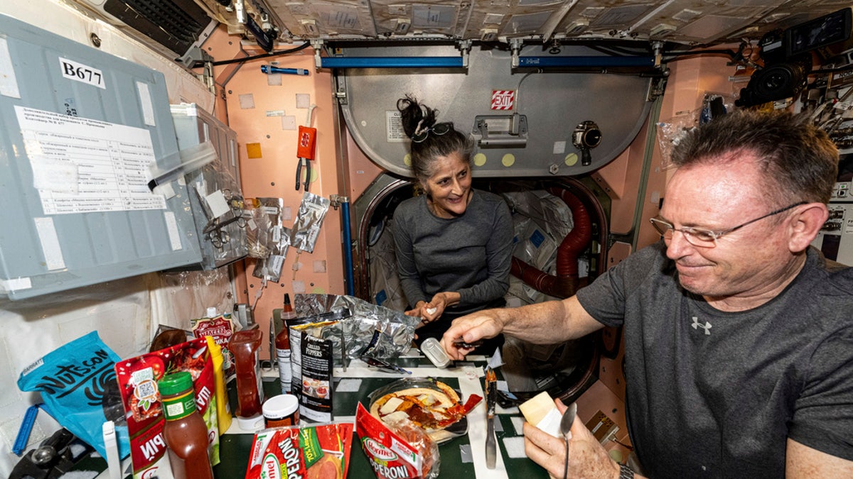 Los astronautas de la NASA Suni Williams y Butch Wilmore, ambos Ingenieros de Vuelo de la Expedición 71, preparan pizza en la cocina de la Estación Espacial Internacional, situada en el interior del módulo Unity, el 9 de septiembre. 