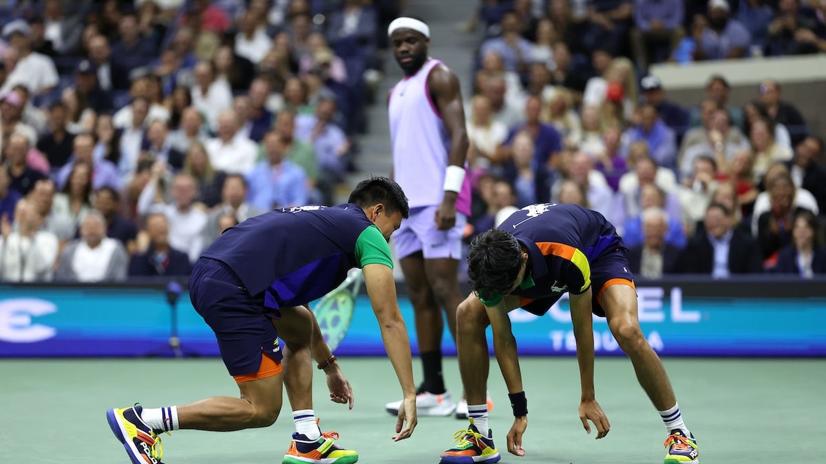 Ball kids attempt to catch a moth