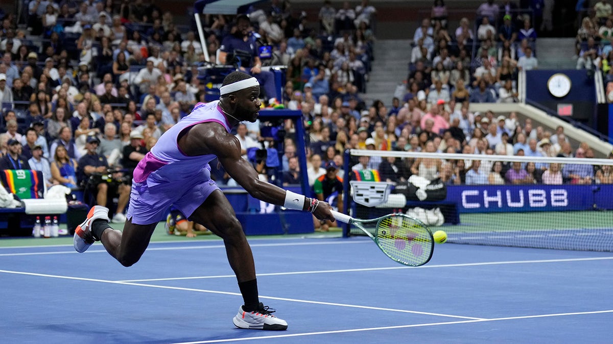 Frances Tiafoe dressed in purple