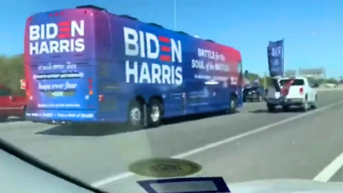 Una camioneta con banderas de Trump flanquea un autobús de campaña de Biden-Harris