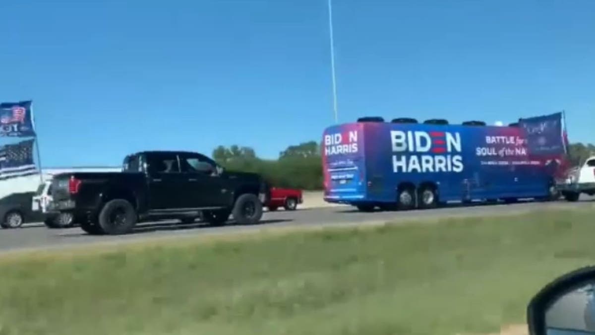 Biden-Harris bus being followed by a pick-up truck