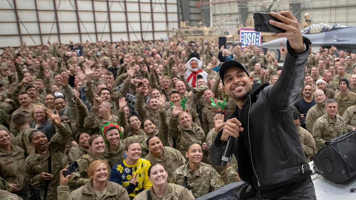 Wilmer Valderrama tomándose una selfie con un grupo de militares.