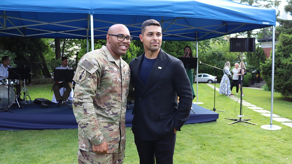 Wilmer Valderrama posing with a soldier.