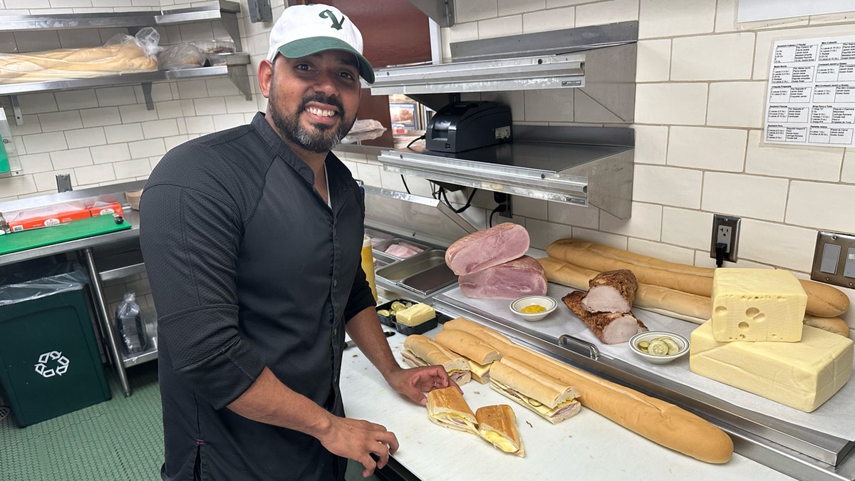 El chef del Versalles, José Bido, posa con el bocadillo cubano que preparó en la cocina del restaurante de Miami, el 26 de septiembre de 2024, en Miami.