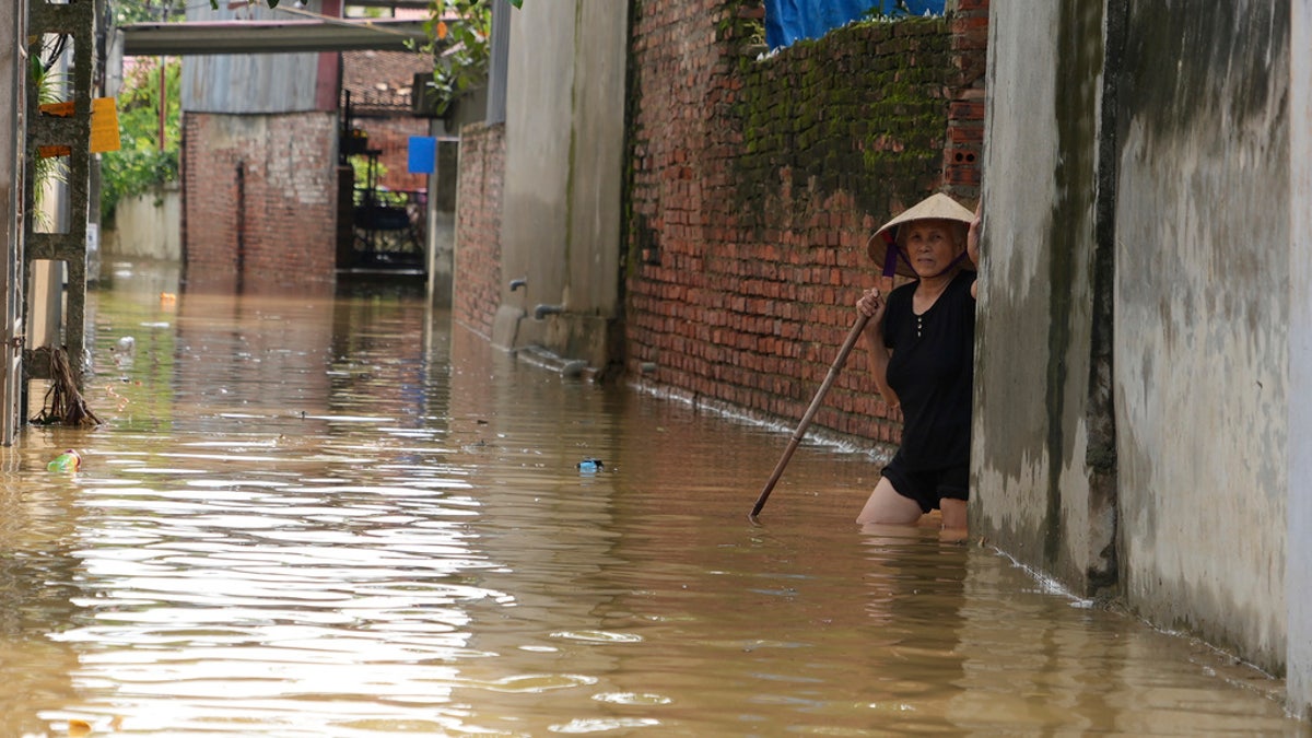 A woman wades in flood in the aftermath of Typhoon Yagi in An Lac village, Hanoi, Vietnam, Friday.