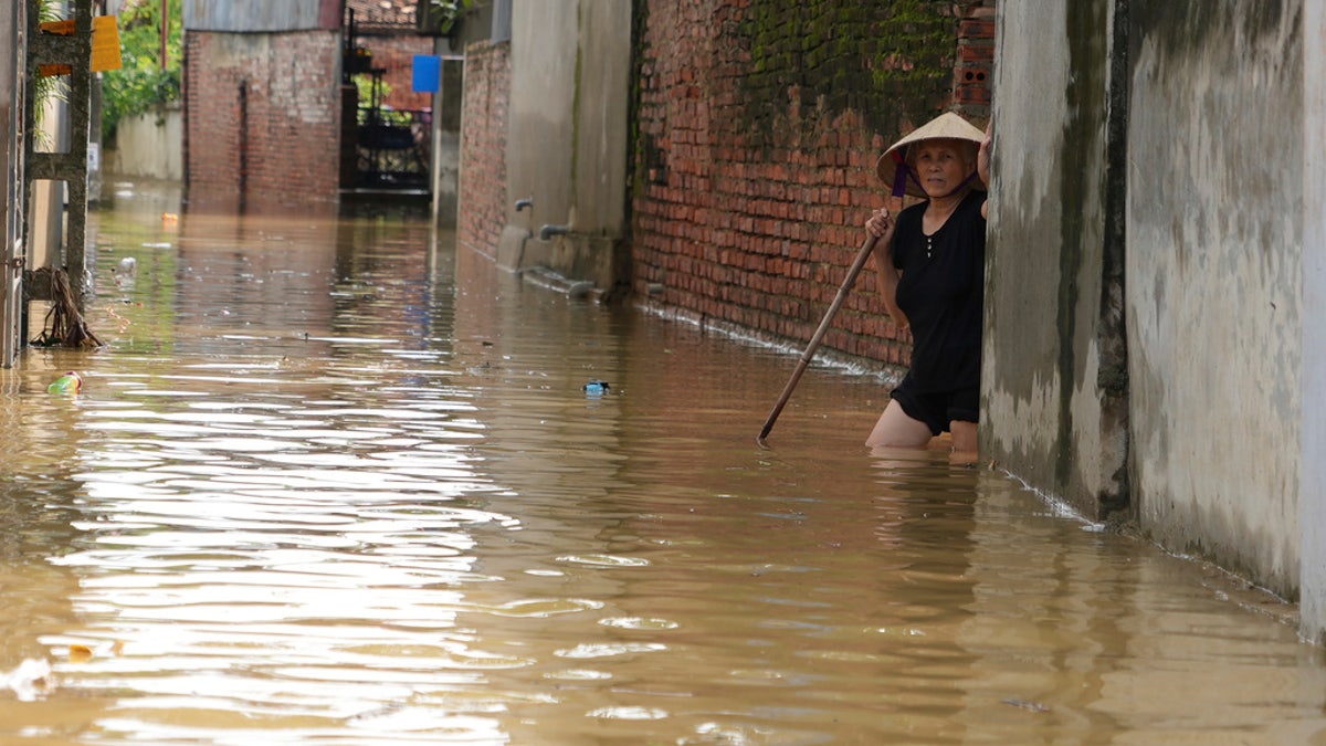 A woman wades in flood in the aftermath of Typhoon Yagi in An Lac village, Hanoi, Vietnam, Friday.