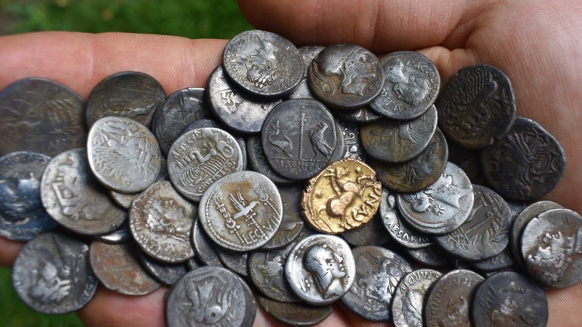 Ancient coins being held 