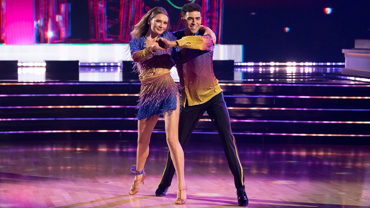 Anna 'Delvey' Sorokin y Ezra Sosa con un atuendo morado y amarillo a juego bailan en "Bailando con las estrellas"