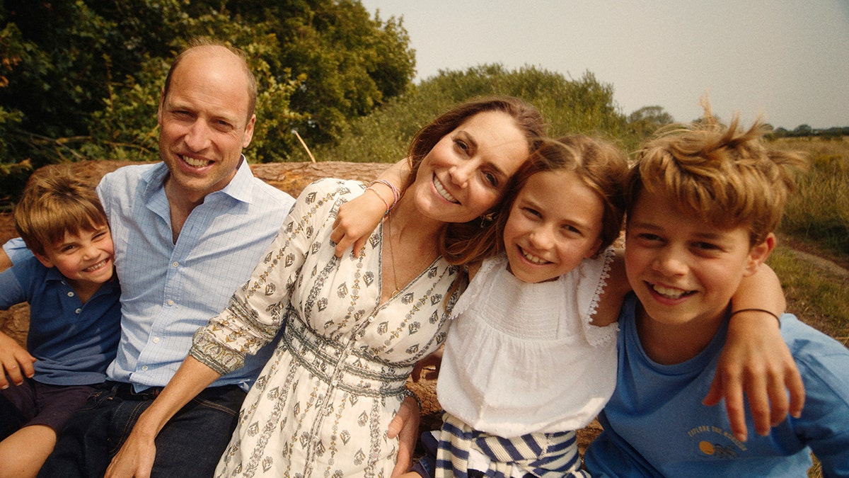 El príncipe Luis, el príncipe Guillermo, la princesa Kate, la princesa Carlota y el príncipe Jorge se apoyan el uno en el otro para un retrato familiar