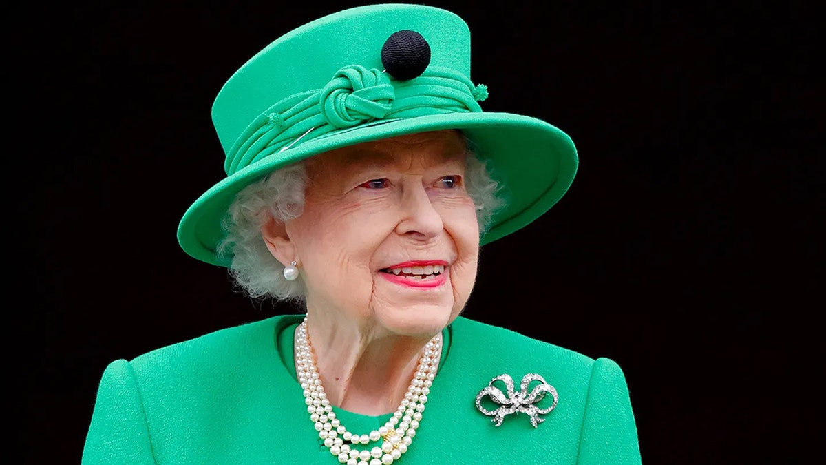 Primer plano de la reina Isabel con un traje verde y un sombrero a juego.