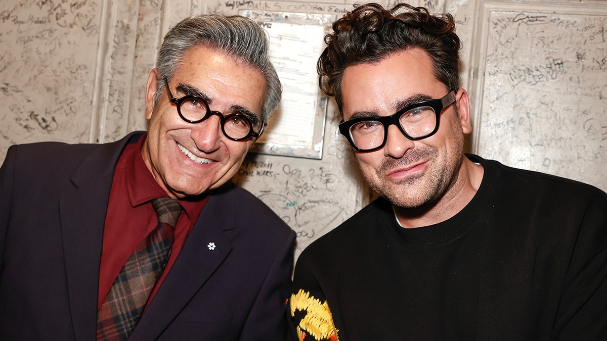 Eugene e Dan Levy posando juntos no lançamento de um livro.