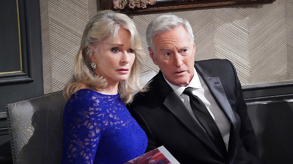 Deirdre Hall in a blue dress as Marlena Evans and Drake Hogestyn in a black suit and tie as John Black in a still "Days of our lives"