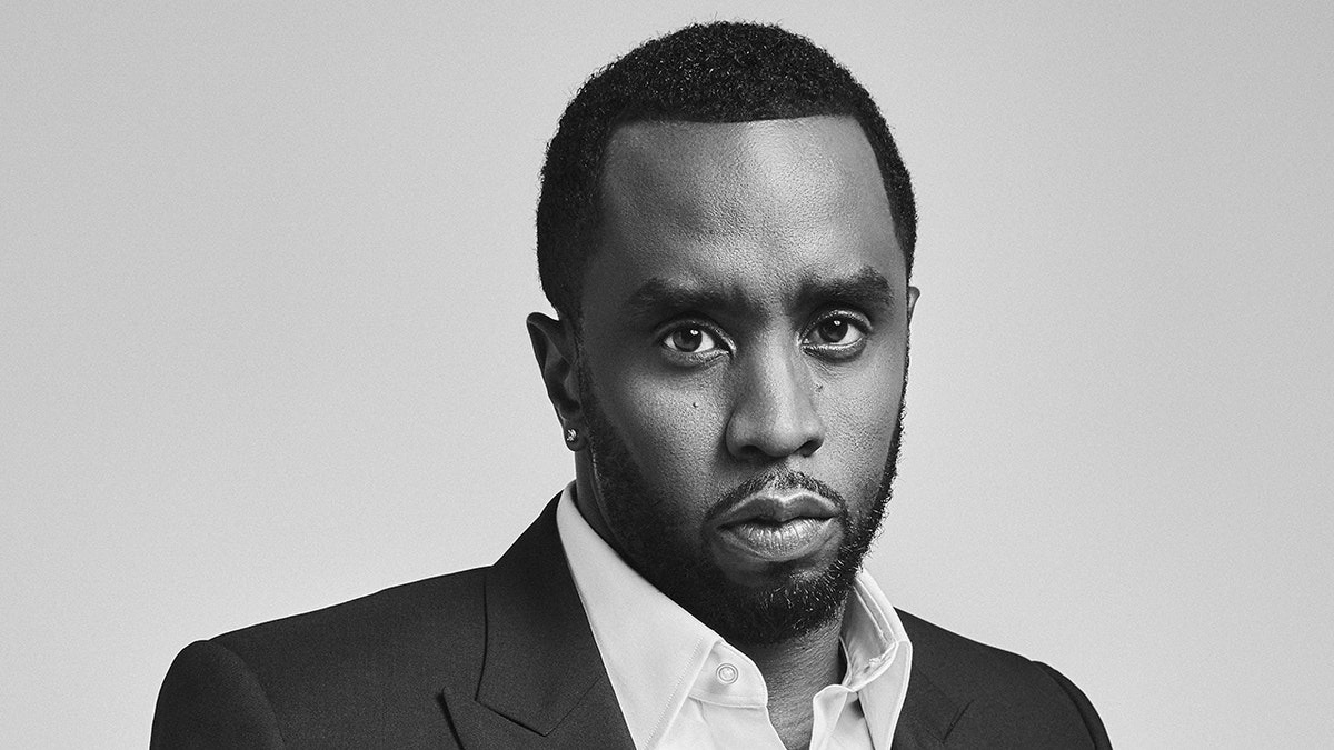 Sean Diddy Combs poses for a portrait session wearing a black suit.