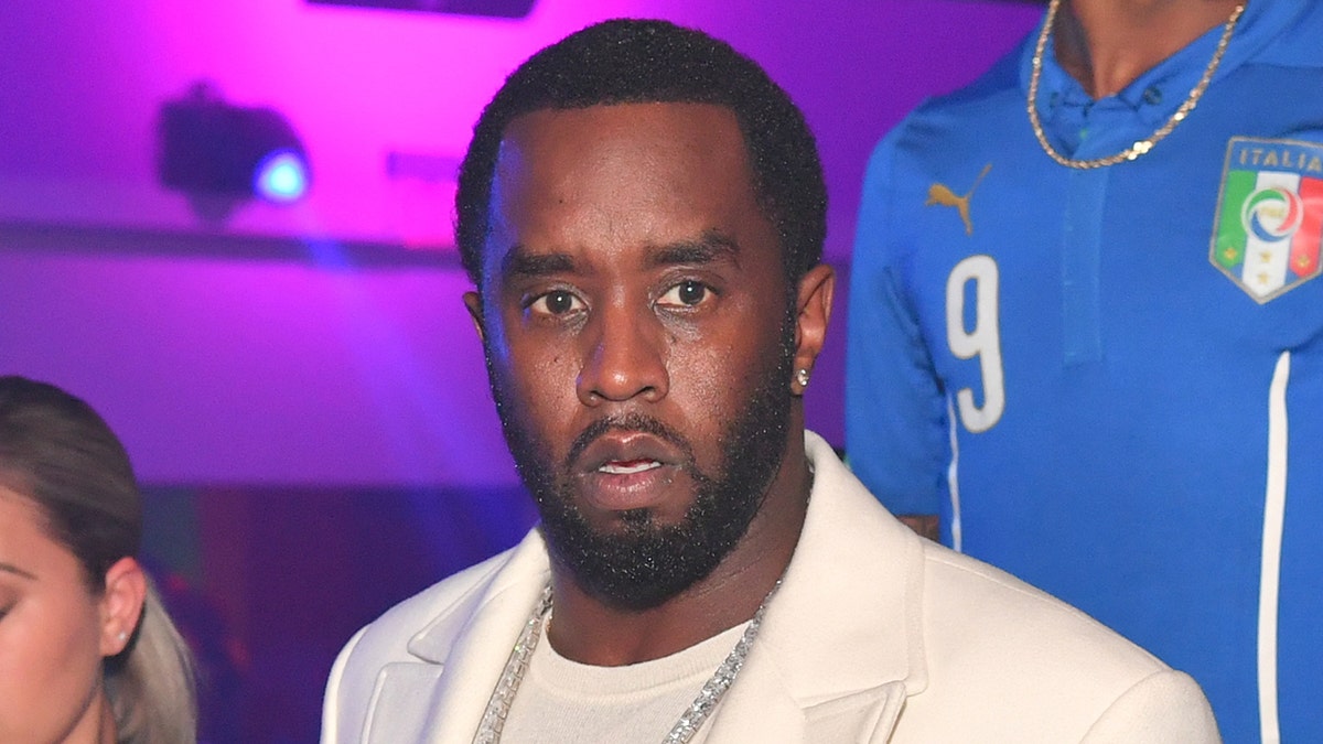 Sean Diddy Combs wychodzi ubrany w białą marynarkę i pasującą koszulę.