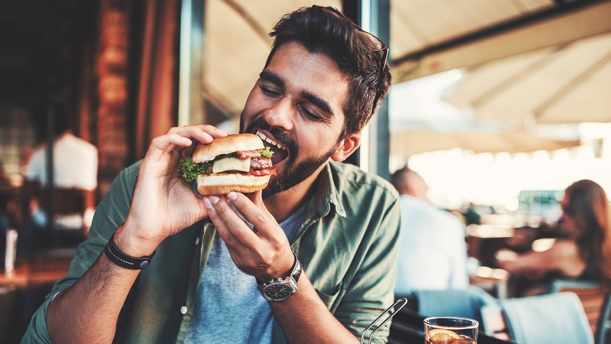 Hombre comiendo hamburguesa