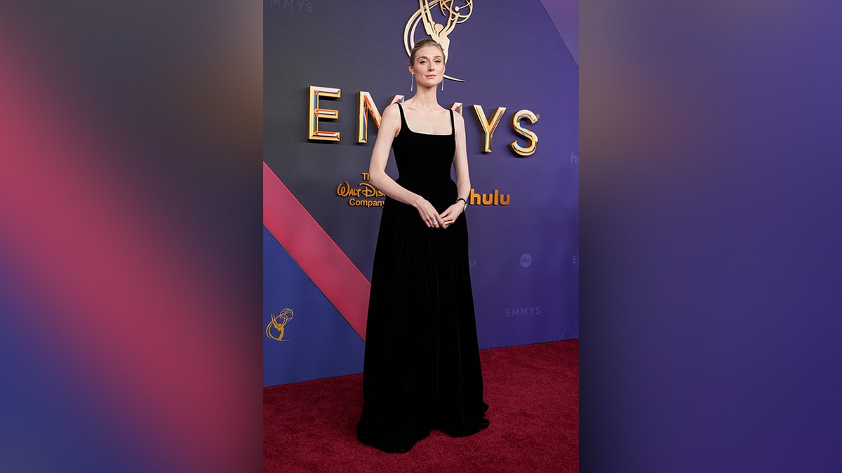 Elizabeth Debicki, dinominasikan atas perannya dalam "Mahkota," mengenakan gaun hitam di karpet merah Emmy Awards 2024.