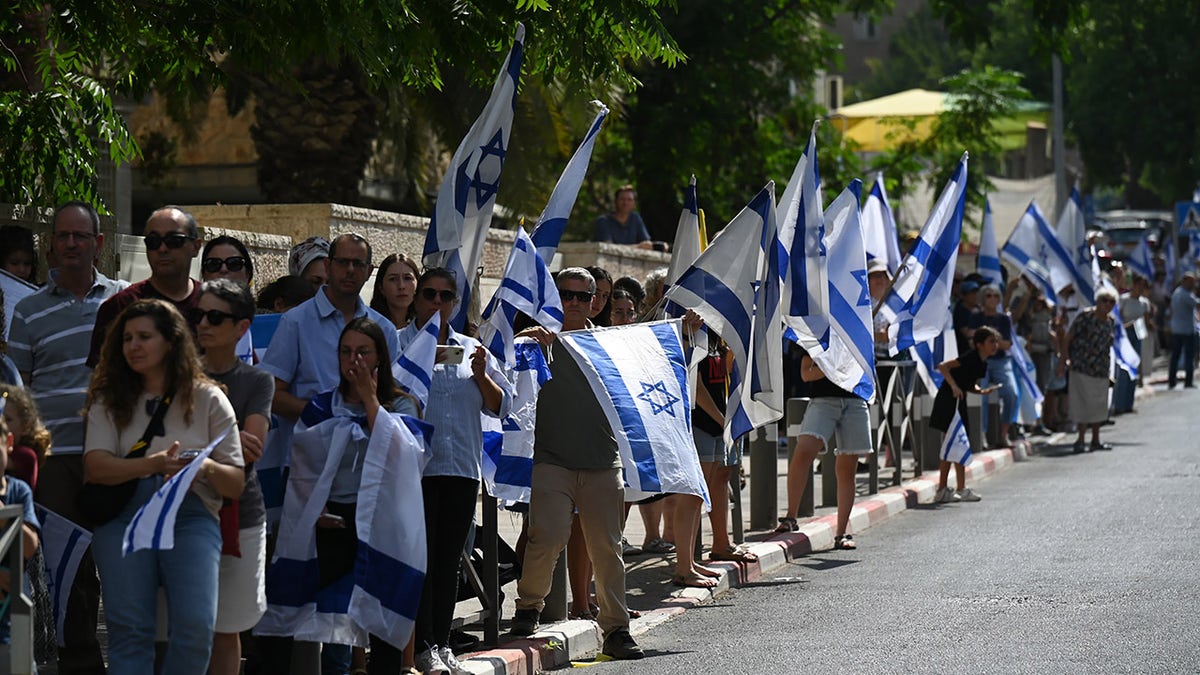 Dolientes portando banderas de Israel