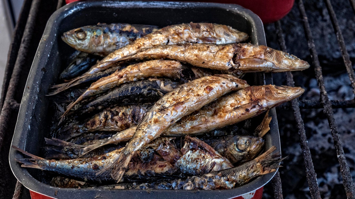 Sardinhas servidas grelhadas, cobertas com azeite e temperos, são um prato obrigatório em Portugal. 