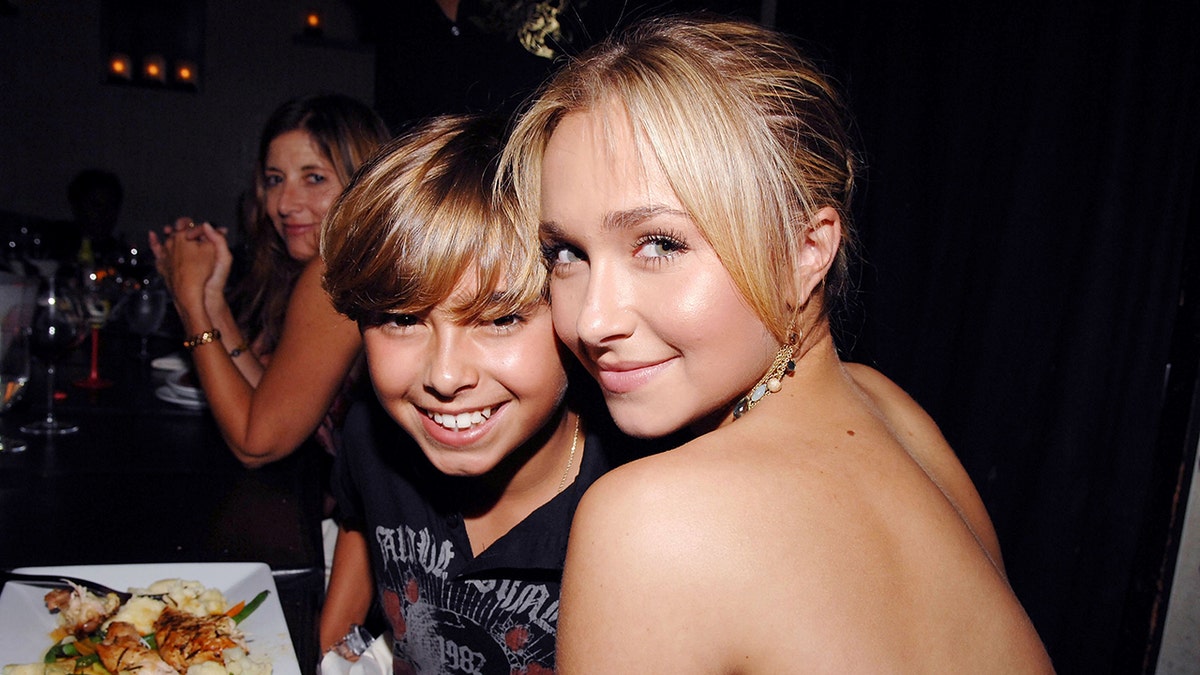 Young Jansen Panetierre smiles broadly with her big sister Hayden Panetierre, who smiles slightly with her back to the camera