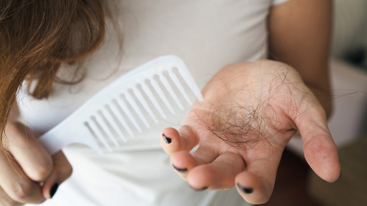 Mujer perdiendo pelo con el cepillo en la mano