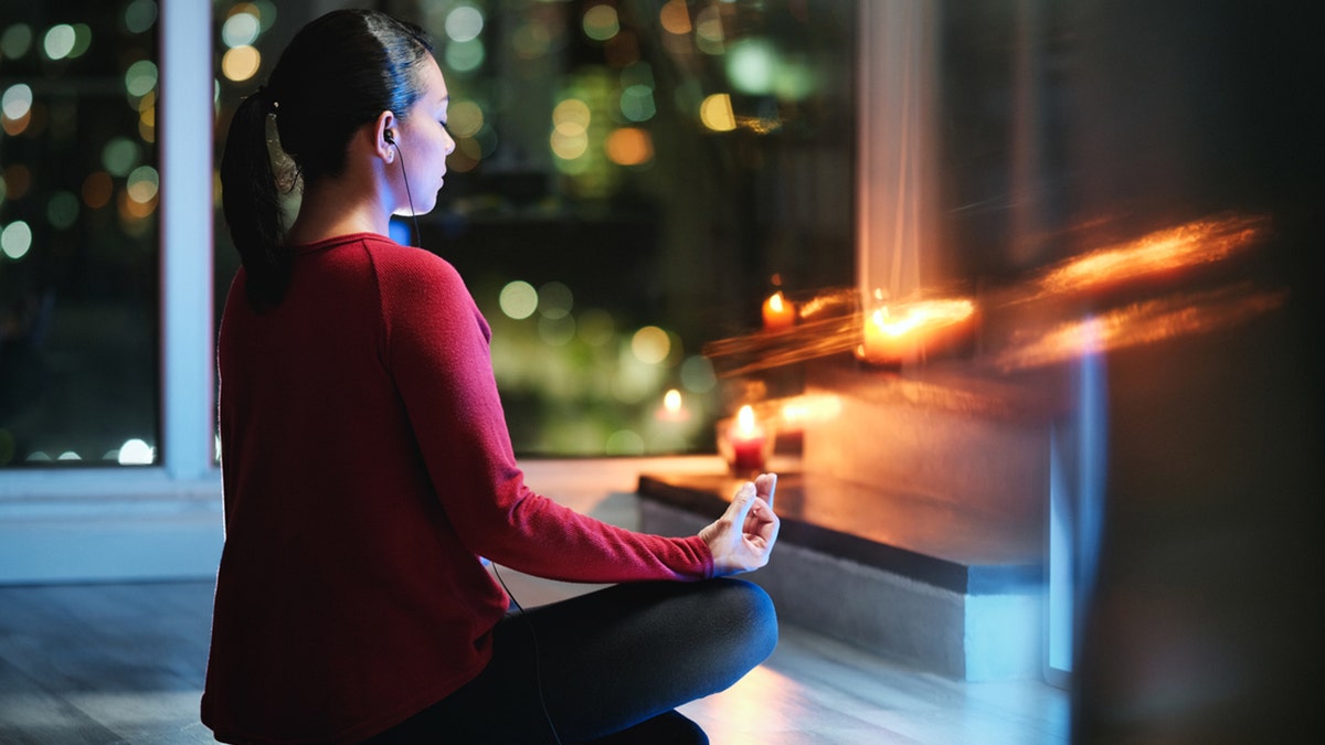 Chica haciendo yoga en casa por la noche.