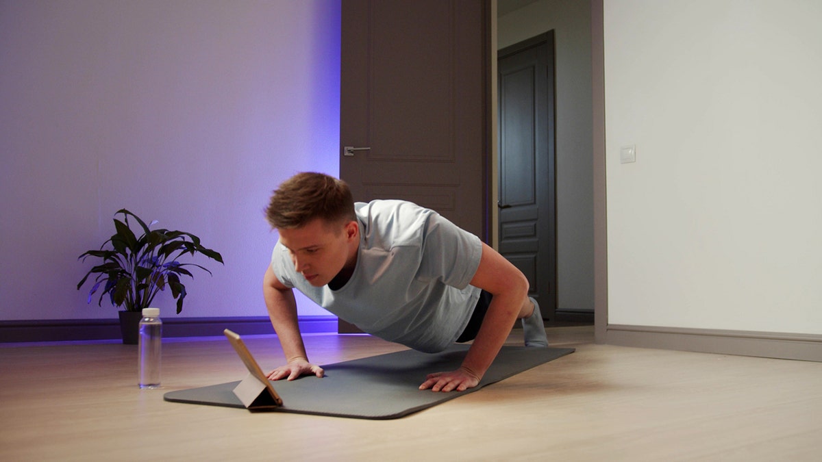 man does push-ups connected  the floor