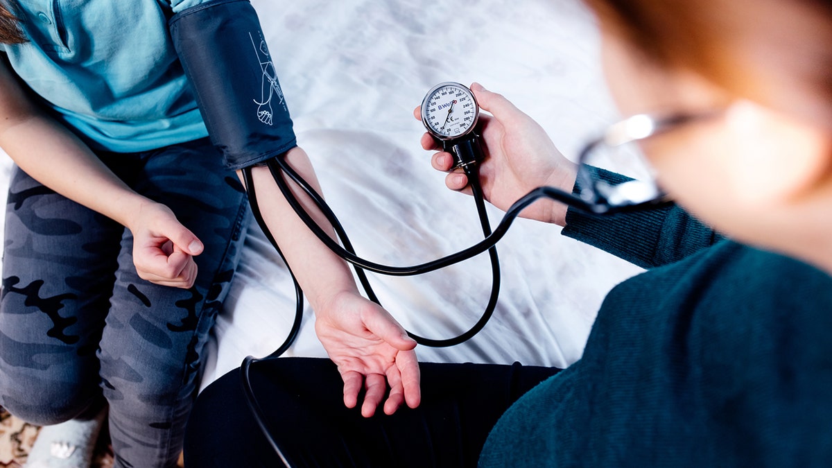 doctor measures blood pressure of a child