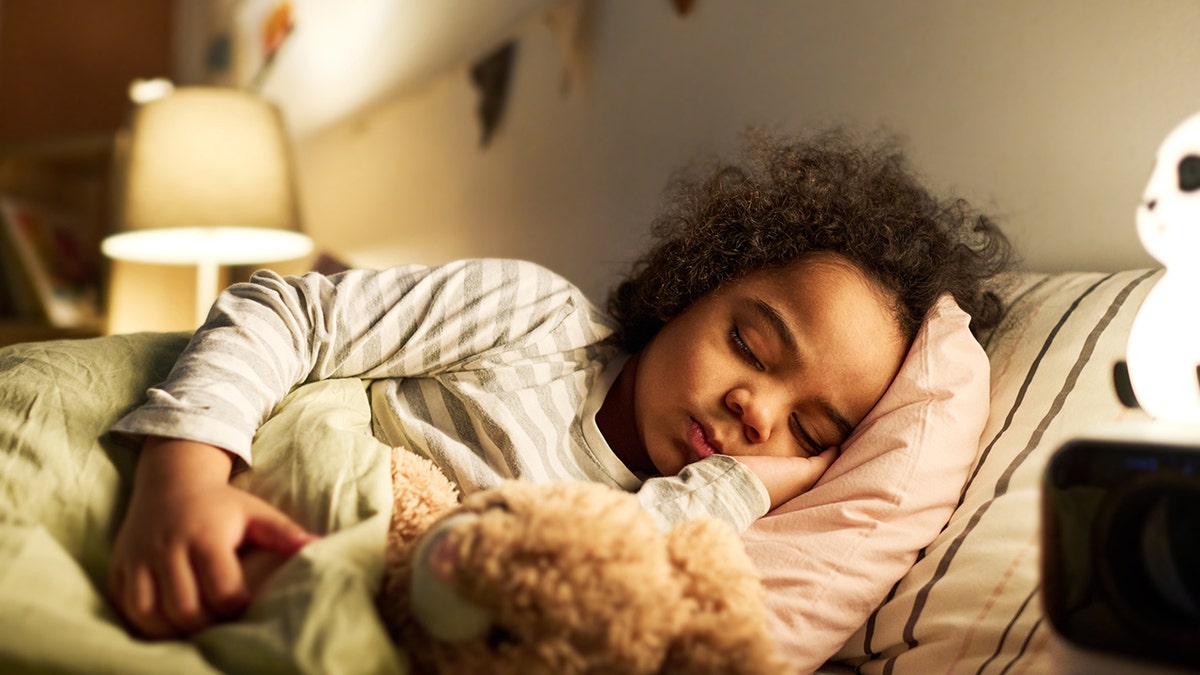 niño durmiendo en la cama con un juguete