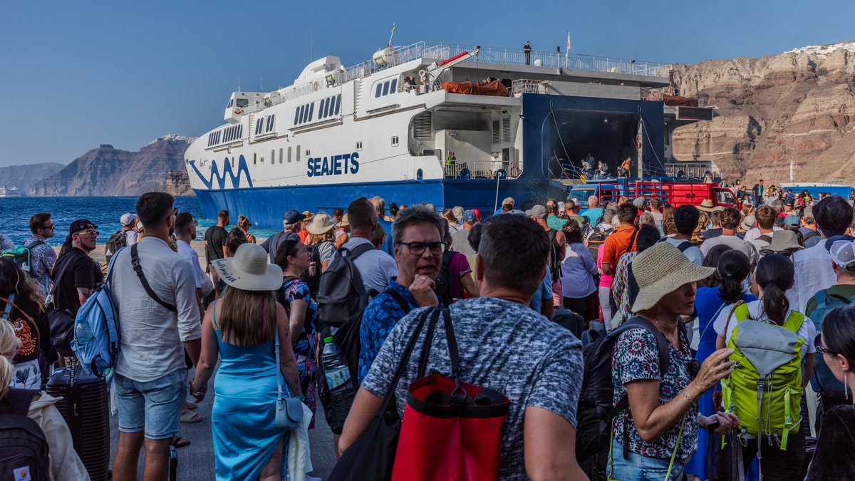 os turistas de todo el mundo llegan o salen del puerto de Thira