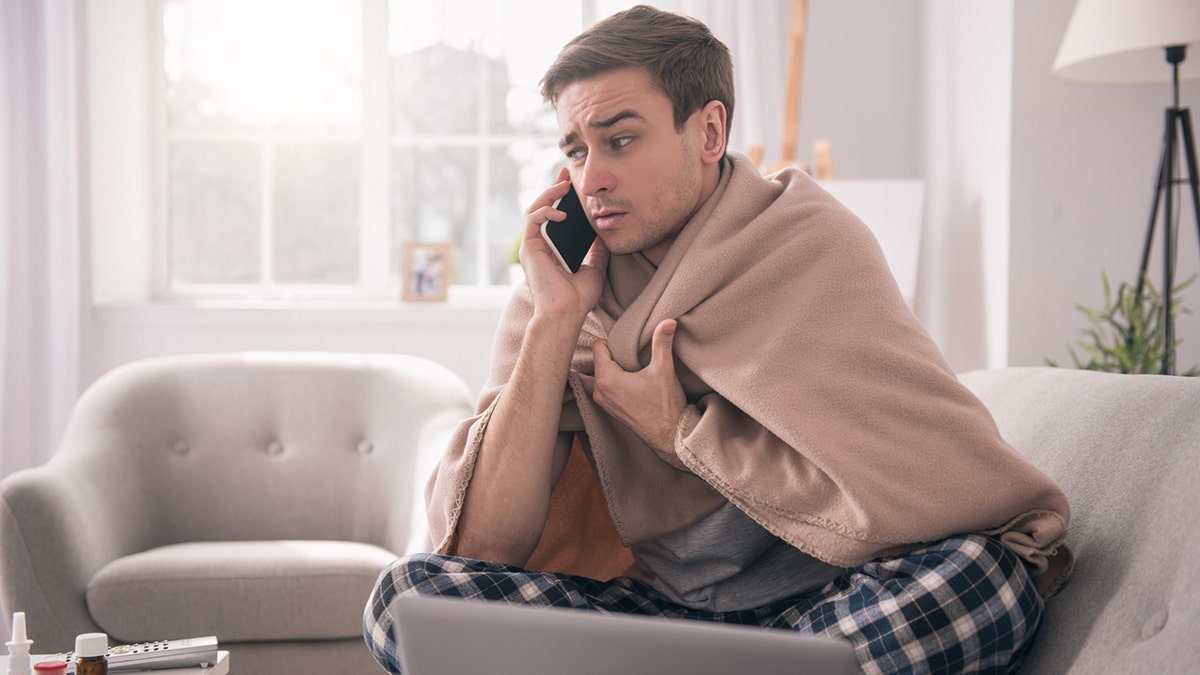 Man on phone with his employer asking about sick leave