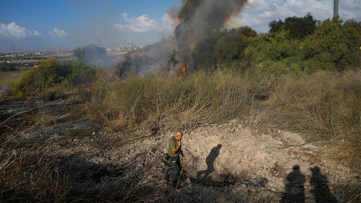 Un agente de policía inspecciona la zona alrededor de un incendio