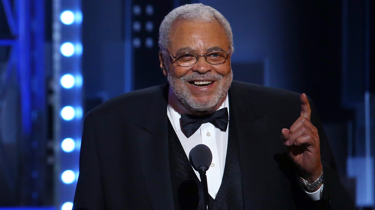 Aktor James Earl Jones tertawa di atas panggung selama acara penghargaan.