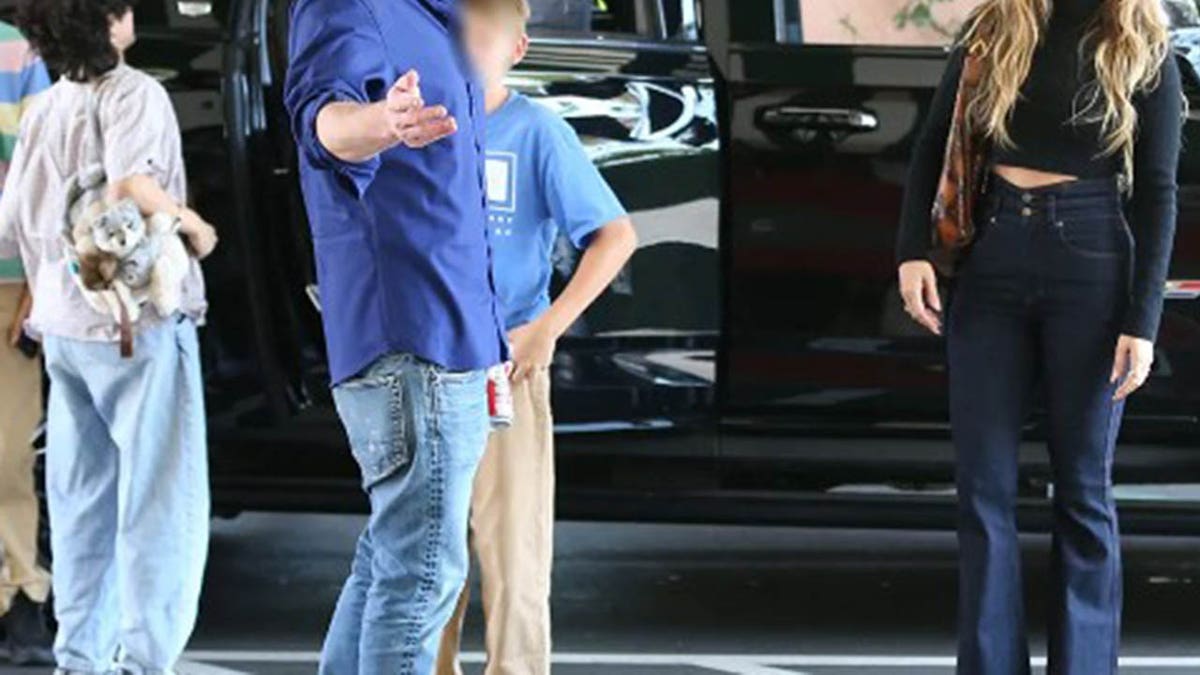 Jennifer Lopez and Ben Affleck stand in front of an SUV