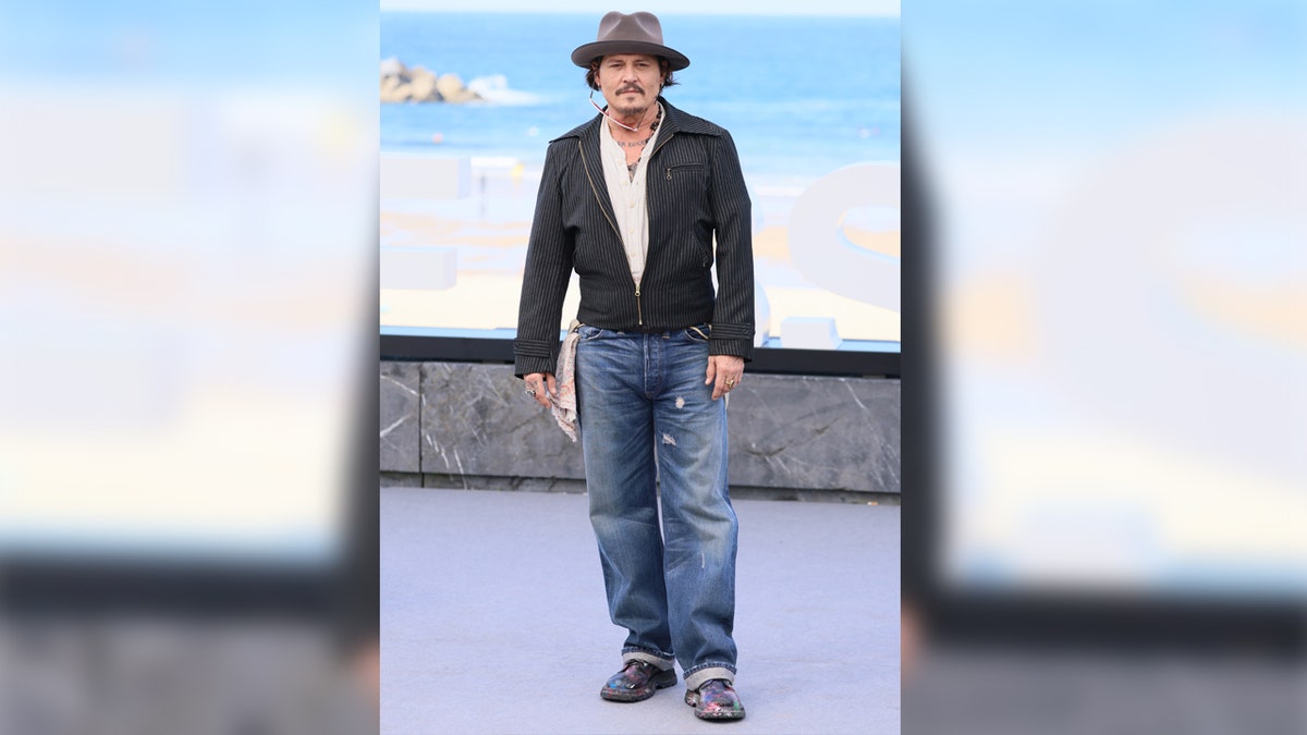 Actor Johnny Depp wears jeans and a leather jacket at film festival.