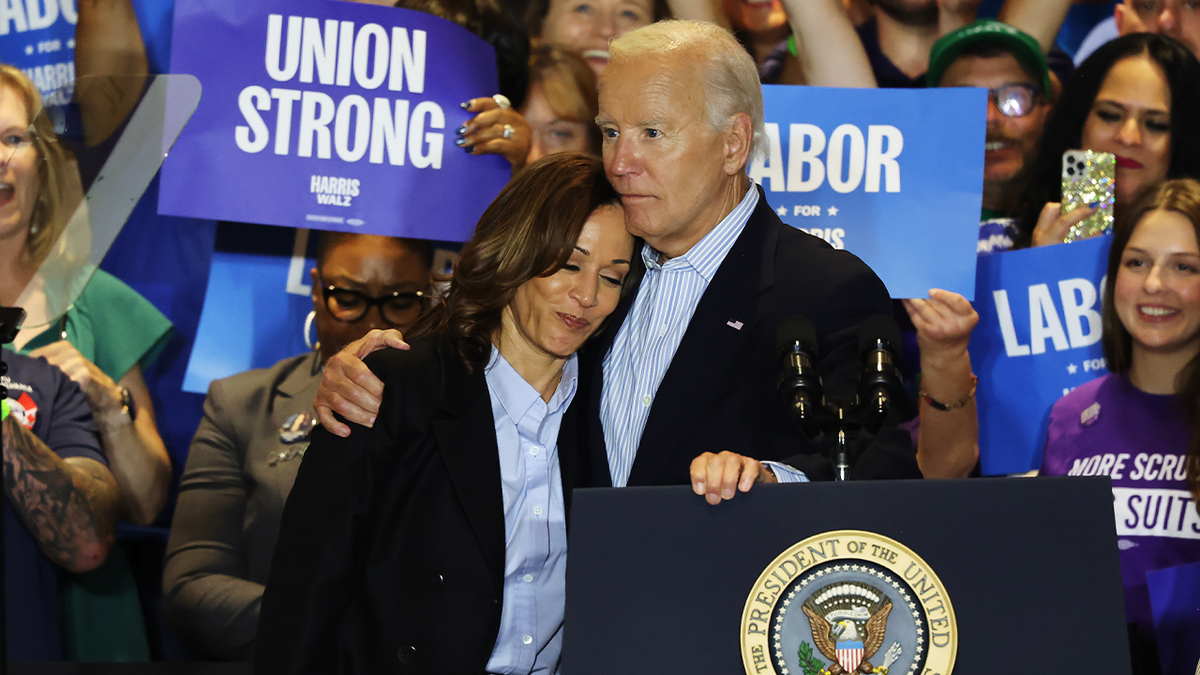 La vicepresidenta Kamala Harris con la cabeza sobre el hombro del presidente Biden en un acto de campaña sindical