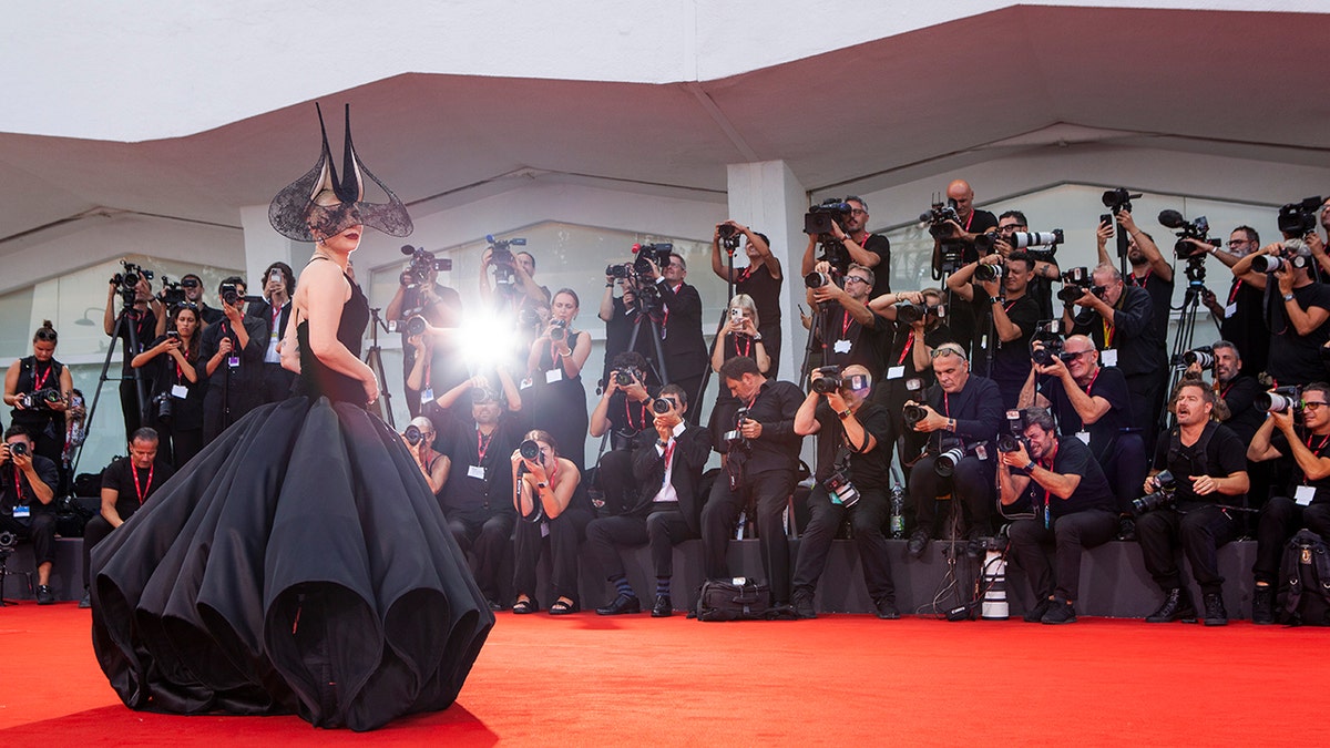 Actress Lady Gaga poses in a black ball gown.