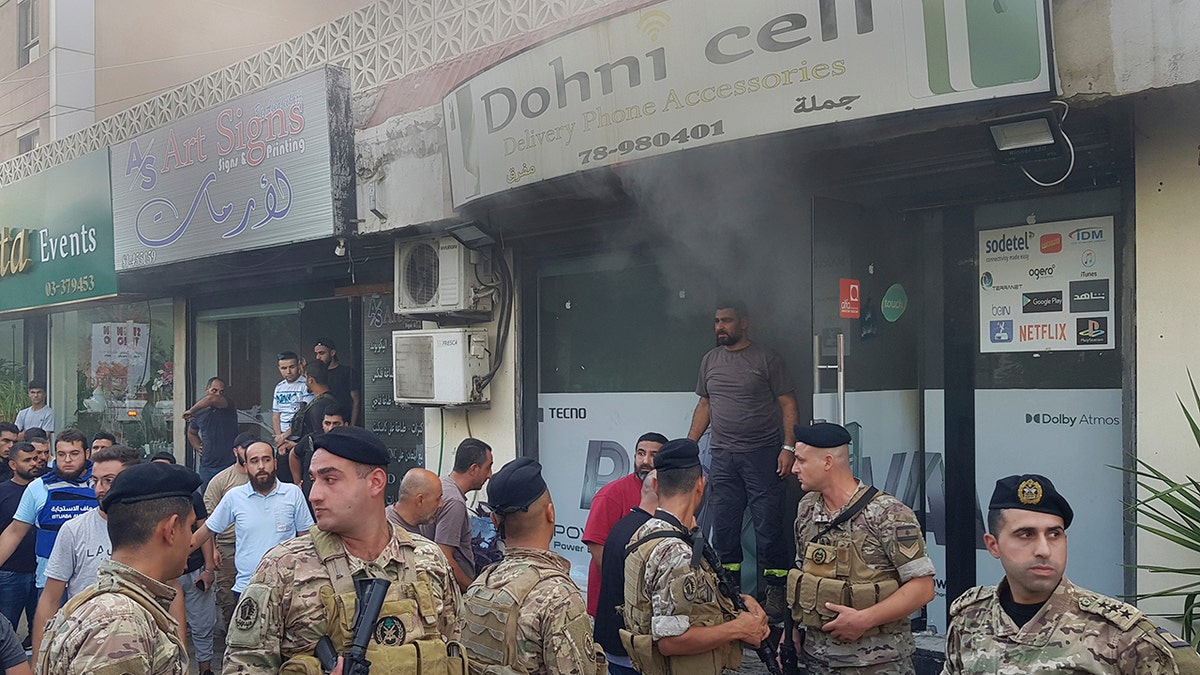 Soldados libaneses frente a una tienda de telefonía móvil dañada