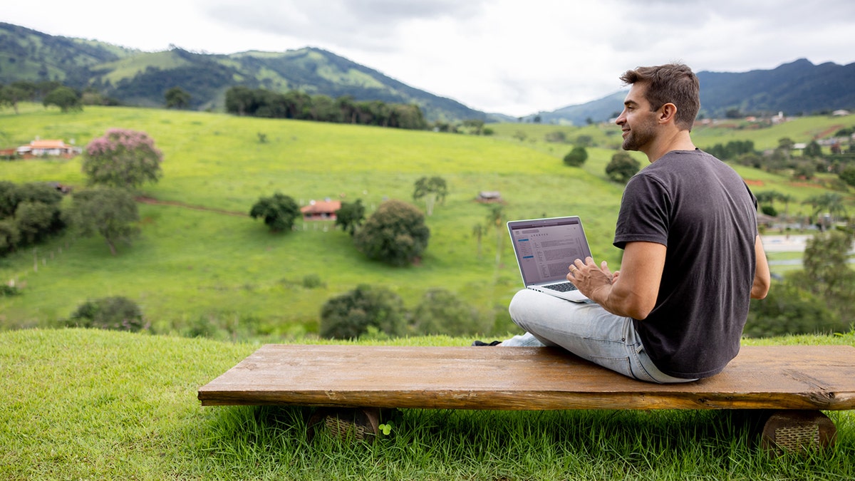 hombre trabajando en un portátil al aire libre