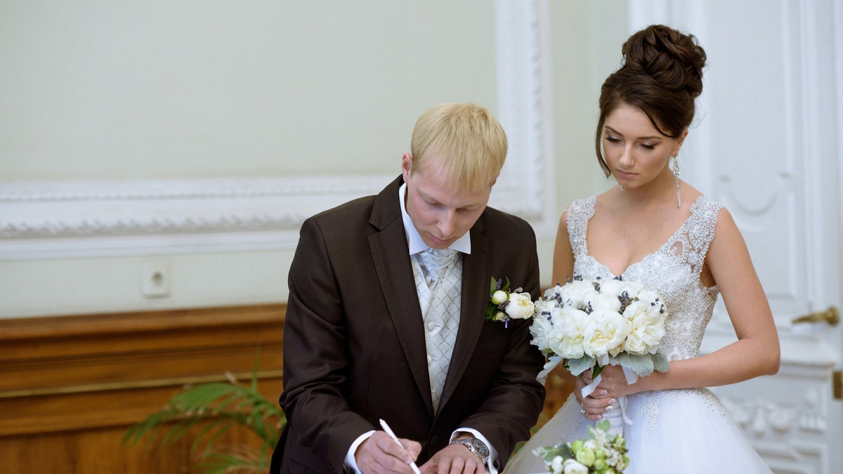 Pareja firma certificado de matrimonio 