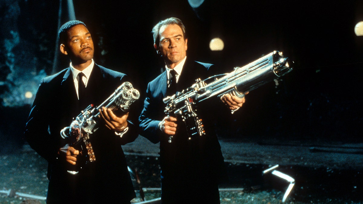 Will Smith y Tommy Lee Jones en "Men in Black", ambos de traje y con grandes armas en la mano