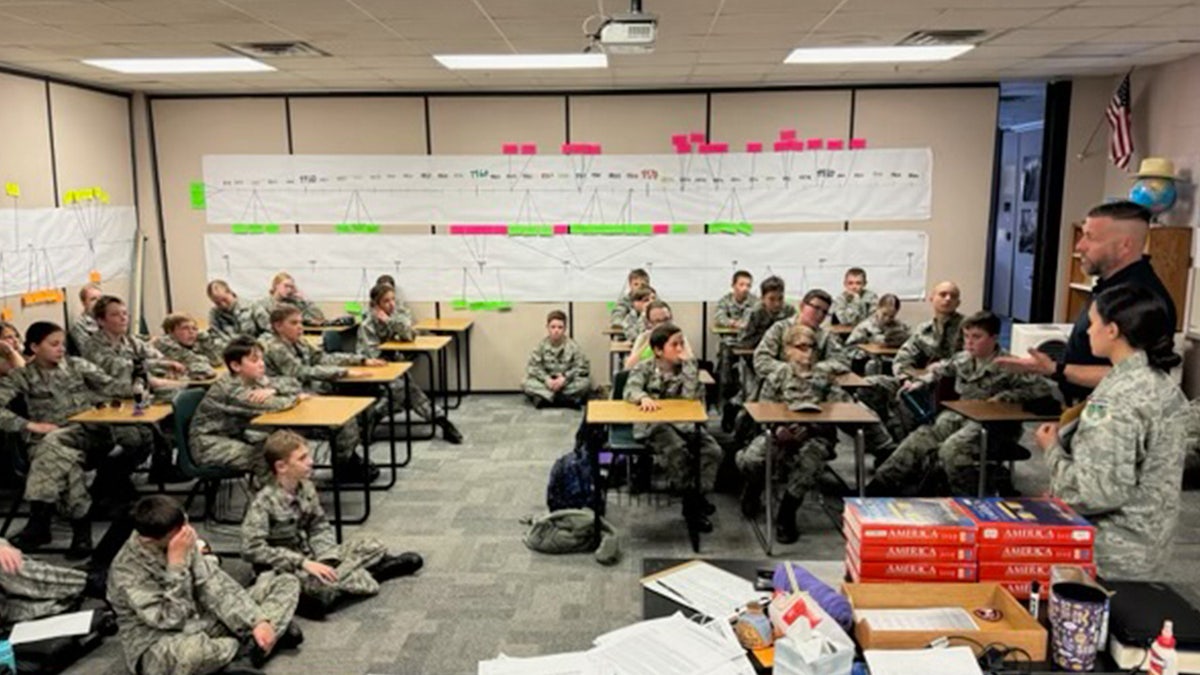 Alumnos vestidos con uniformes de camuflaje sentados en el aula