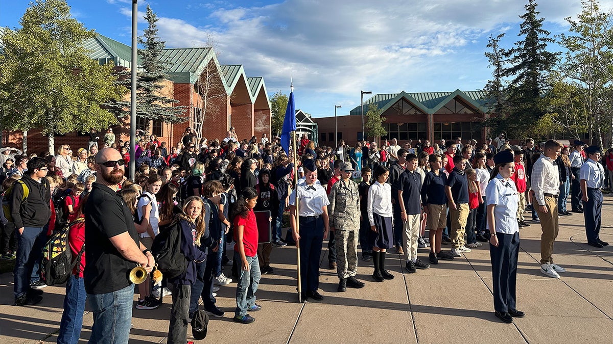 Merit Academy students stand outside during ceremony