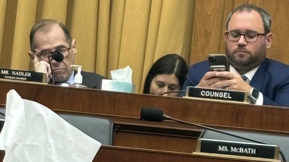 Rep Nadler closes his eyes as an aide looks at a cell phone