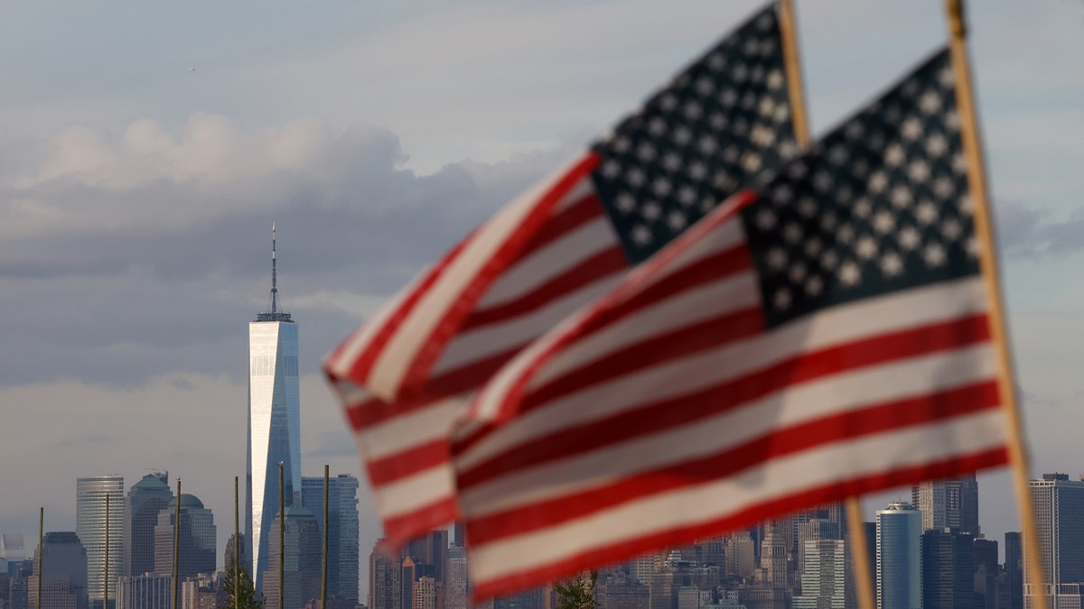 Two American flags with Manhattan skyline in background