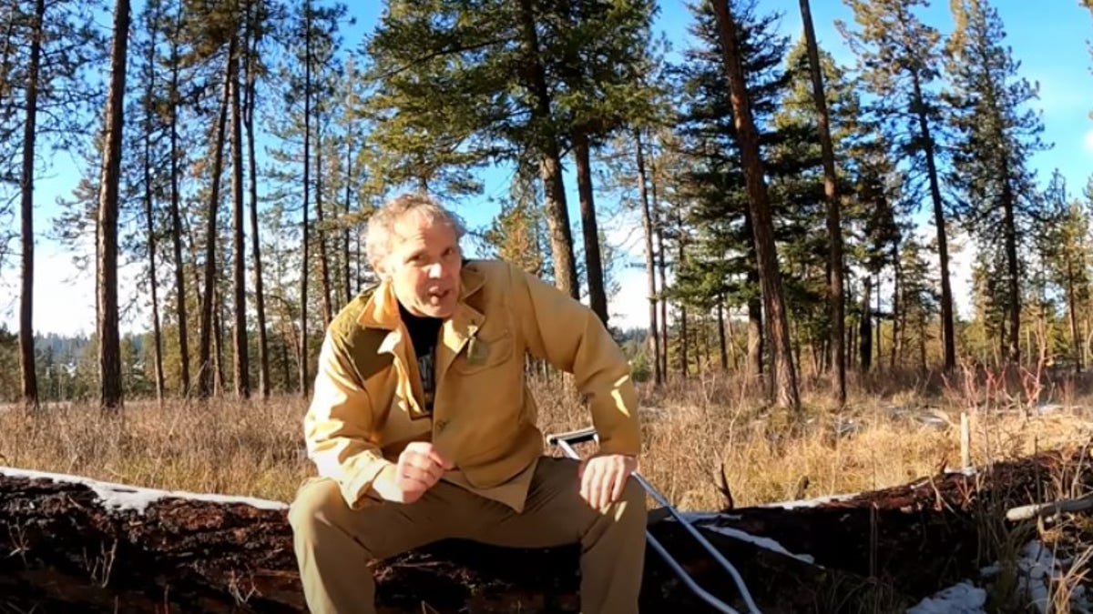 Paul Harrell sits on a tree trunk in the last video