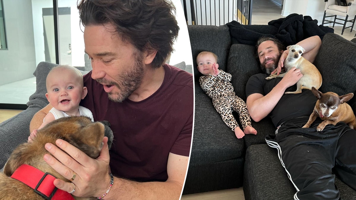 Tom Pelphrey sostiene a su hija Matilda mientras acaricia a un perro partido Tom Pelphrey y Matilda se tumban en el sofá con dos perros pequeños