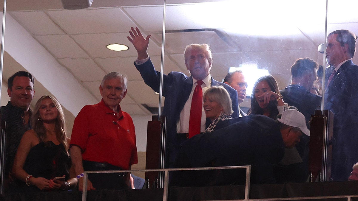 Trump waves in suite